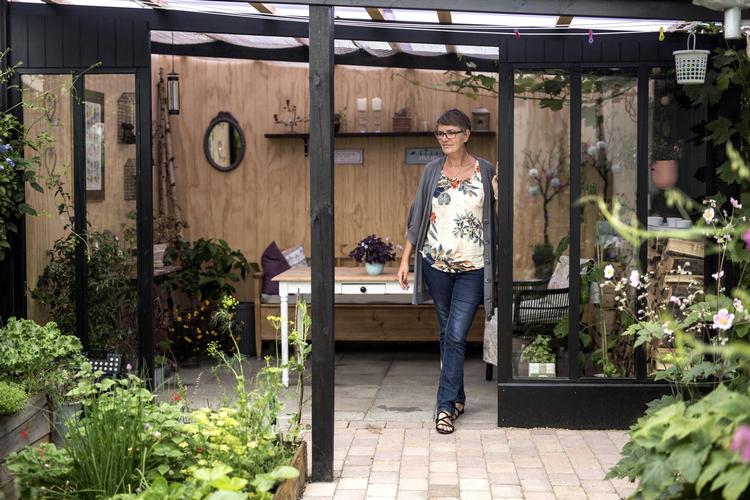 Ved at vælge et kolonihavehus i en forening med helårsbeboelse har Britta Hansen kunnet købe sit eget hus med frodig have til. 