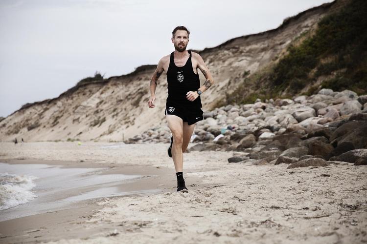Ned i tempo. »Det er altså bare ret anderledes at tage et par shorts og en T-shirt på end at pakke sig ind i alt muligt regntøj«, siger den tidligere eliteløber Mikkel Borg Bjergsø, der sammen med sin kone købte sommerhus ved Vejby Strand for syv år siden. Hvis han skulle vælge mellem sit hjem på Frederiksberg og sommerhuset, ville han vælge sidstnævnte: »Vores piger er vokset op her, så det betyder også rigtig meget for dem«. Foto: Ditte Valente
 
