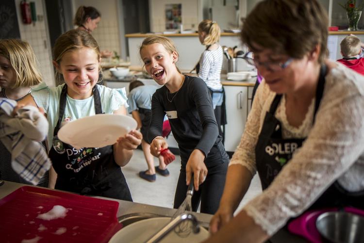 Clara Marie Højholm Rolsted og Liva Rud Lilholm vasker op i eksotisk plastbalje med frivillig Pia Beck. 