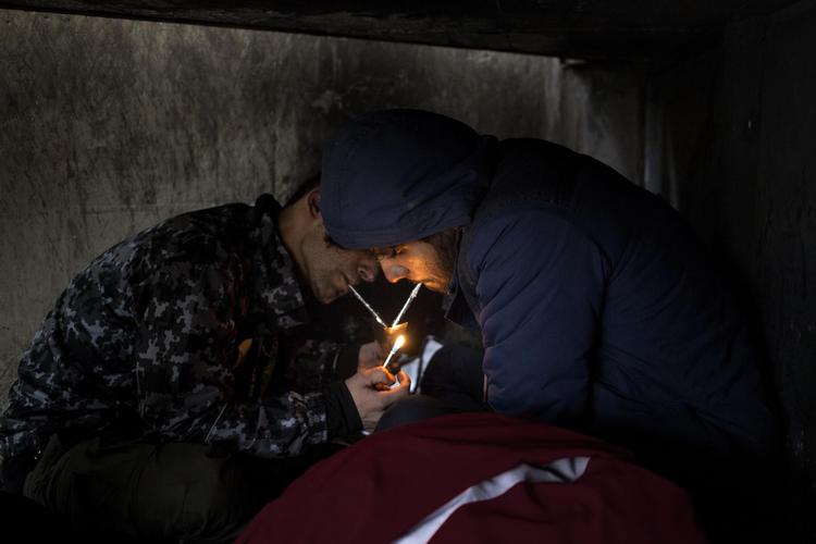 Arash (tv) og Malid ryger heroin i rør af sølvpapir gennem store dele af natten, som de tilbringer under tilkørselsramperne i Den Brune Kødby. 