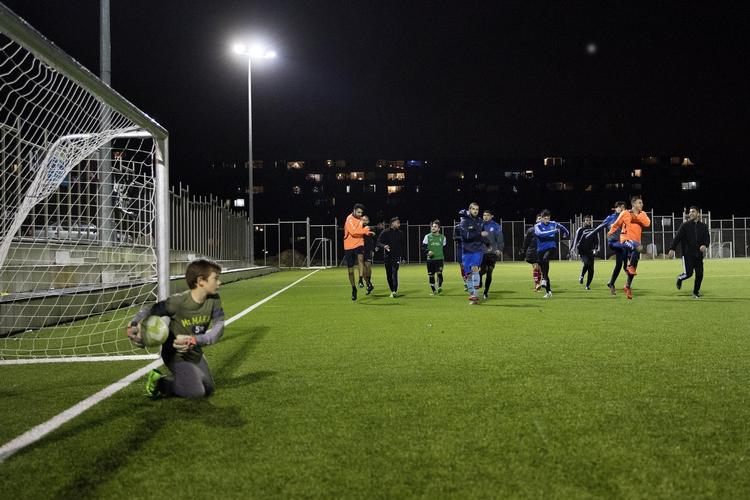 Det stærkeste seniorhold i den lokale fodboldklub ACFC træner om aftenen på kunstgræsbanen. 