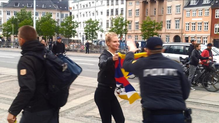 Sara Berthou nåede kun at vise det tibetanske flag i få sekunder på Christiansborg Slotsplads, før en betjent flåede det fra hende. »Det er da ikke ulovligt«, forsøgte hun. »I dag er det«, svarede betjenten ifølge Sara Berthou. 