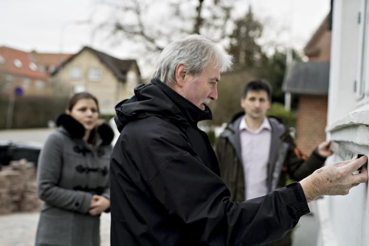 Audrone og Paulius Nekrasas (begge i baggrunden) tegnede en udvidet ejerskifteforsikring i Tryg og betalte 65.000 kroner for den. Men selv om huset havde alvorlige skjulte skader, som ikke var omtalt i tilstandsrapporten, har de ikke fået erstatning. Arkitekt Sven-Henrik Brandstrup (forrest) har bistået familien og været med til at undersøge skaderne.  