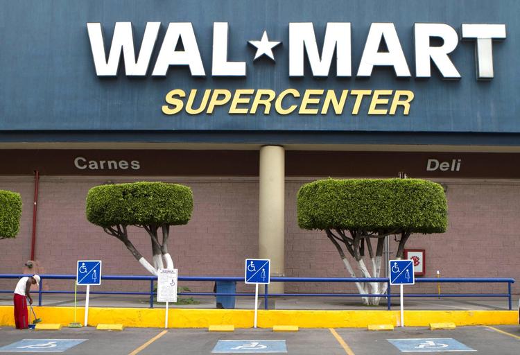 En ansat fejer P-pladserne uden for en af Walmarts butikker i Mexico By. Den amerikanske er i dag den største private virksomhed i Mexico. 