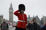 Alvorligt vagtskifte ved Westminster Bridge i London og fjollede turister. Foto: Matt Dunham/AP
 