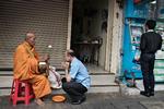 Overalt i Thailand kan man om morgenen se munke, der samler mad ind. Her har en mand givet lidt til en munk i Bangkok, som til gengæld giver ham en form for velsignelse. Men stadig flere thailændere vender sig mere mod det moderne forbrugersamfund og ofrer ikke munkene stor opmærksomhed. (Arkivfoto) 