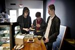 Ved frokosttid stimler studerende fra det nærliggende handelsgymnasium sammen omkring madbaren, hvor man får serveret retter som kylling i karry i plastikbokse. 