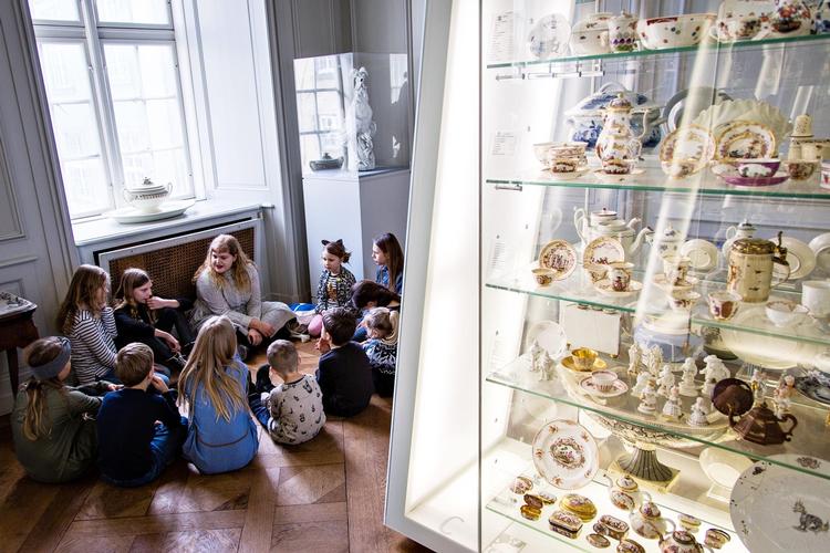 Børnene funderer kreativt over hverdagens designgenstande, når rundviser Anna Sofie Mørch Bendixen, siddende ved radiatoren, fortæller historien bag f.eks. en tallerken. 
