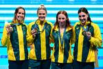 Australierne Mollie O'callaghan, Shayna Jack, Emma Mckeon and Meg Harris poserer med deres guldmedaljer efter sejren i kvindernes 4x100 meter fri lørdag aften. Foto: Manan Vatsyayana/Ritzau Scanpix