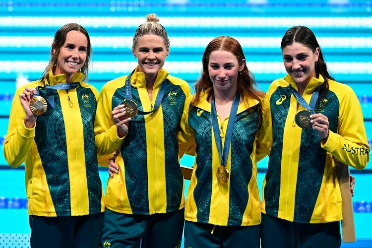 Australierne Mollie O'callaghan, Shayna Jack, Emma Mckeon and Meg Harris poserer med deres guldmedaljer efter sejren i kvindernes 4x100 meter fri lørdag aften. Foto: Manan Vatsyayana/Ritzau Scanpix