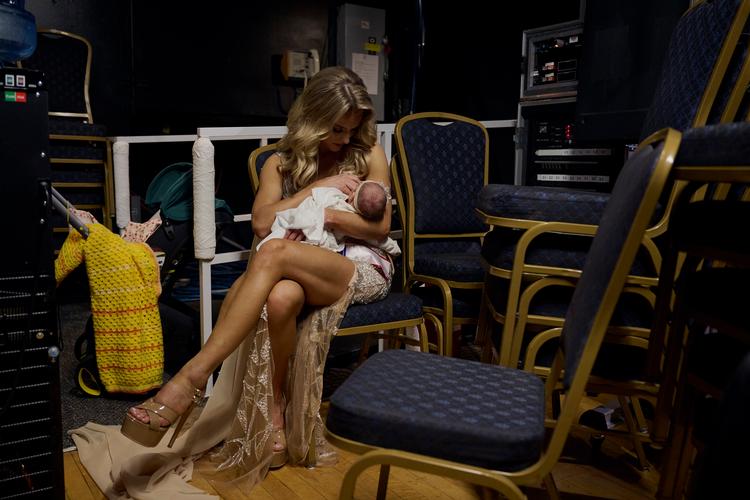 På femtedagen efter fødslen af sit ottende barn Flora var Hannah Neeleman i tvivl, om hun kunne deltage i Mrs. World. »Jeg blødte og var hævet, og mælken begyndte at løbe til«.  Men på syvendedagen rejste hun sig. Her backstage i Las Vegas med den nyfødte i favnen.  Foto: Bridget Bennett/Ritzau Scanpix