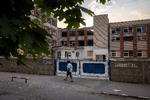 En kvinde passerer en skole i Pokrovsk, der er ødelagt af russisk beskydning. Foto: Thomas Peter/Ritzau Scanpix