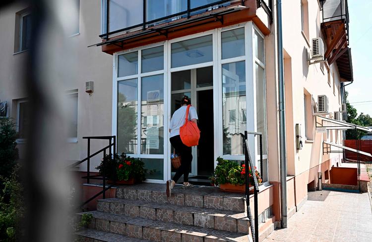 En kvinde på vej ind i det ferskenfarvede hus i Budapest. Selskabet BAC, som angiveligt producerede eksplosive personsøgere til Hizbollah-militsen, har sit hovedsæde her. Foto: Attila Kisbenedek/Ritzau Scanpix