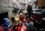 Redningsarbejdere evakuerer lokale væk fra oversvømmelserne i Nepals hovedstad, Kathmandu, hvor Bagmati-floden er gået over sine bredder efter voldsomt regnvejr. Foto: Navesh Chitrakar/Ritzau Scanpix