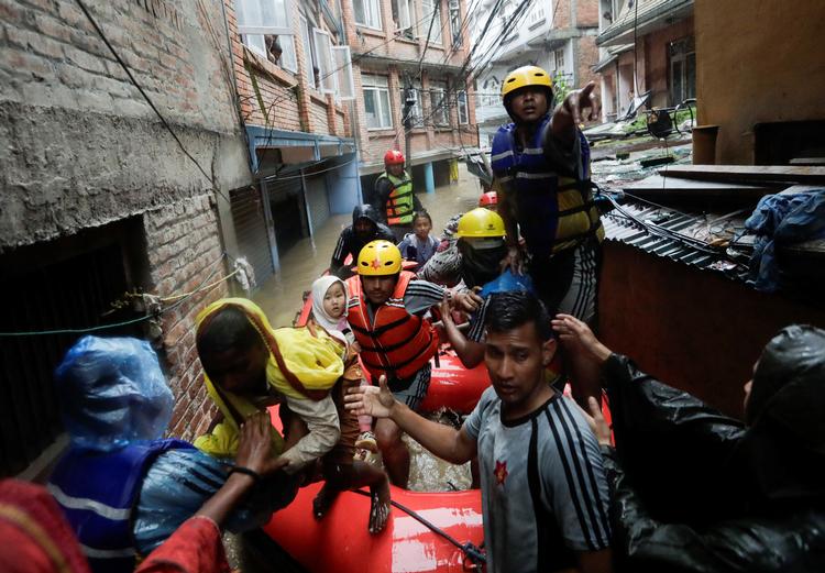Redningsarbejdere evakuerer lokale væk fra oversvømmelserne i Nepals hovedstad, Kathmandu, hvor Bagmati-floden er gået over sine bredder efter voldsomt regnvejr. Foto: Navesh Chitrakar/Ritzau Scanpix