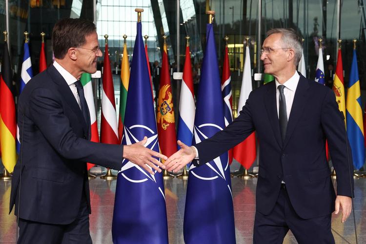 Den nye og afgørende generalsekretør for Nato giver hånd. Mark Rutte til venstre og Jens Stoltenberg til højre. Foto: Yves Herman/Ritzau Scanpix
