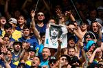 En fan af Boca Juniors holder en T-shirt i vejret med et billede af Diego Maradona.  Foto: Alejandro Pagni/Ritzau Scanpix