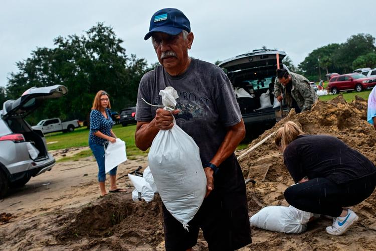 Indbyggere fylder sække med sand, som skal beskytte deres hjem mod mulige oversvømmelser som følge af orkanen Milton, der forventes at ramme Florida natten til torsdag.  Foto: Giorgio Viera/Ritzau Scanpix