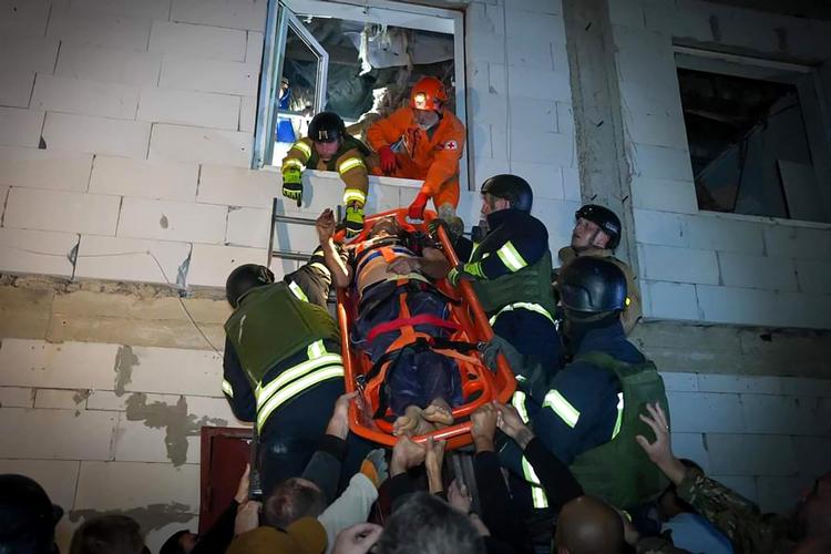 Redningsmandskab gelejder en person ud af den beboelsesejendom, som blev ramt af et missil natten til fredag i Odesa-regionen. Foto: Handout/Ritzau Scanpix