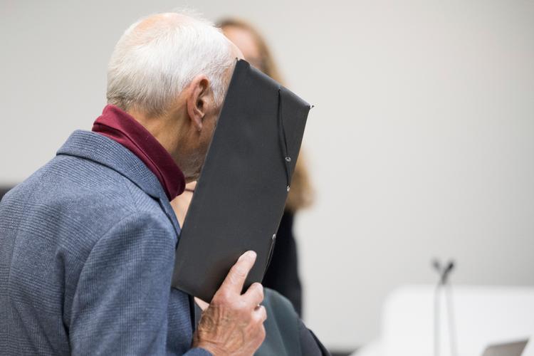 Den 80-årige tidligere Stasi-officer dækkede sit ansigt til, da dommen skulle afsiges. Han fik ti års fængsel. Foto: Sebastian Gollnow/Ritzau Scanpix