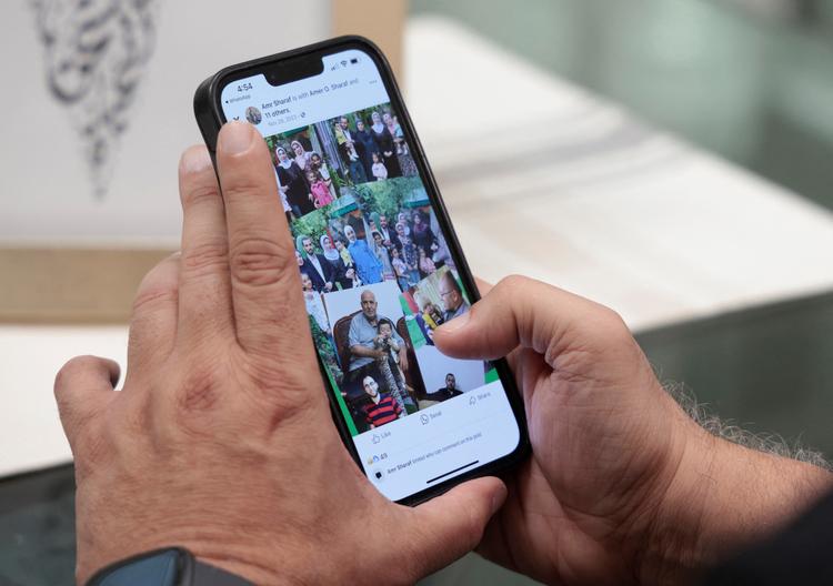 En palæstinenser bosiddende i USA viser billeder fra Facebook af sine familiemedlemmer, der er blevet dræbt i Gaza.  Foto: Rebecca Cook/Ritzau Scanpix
