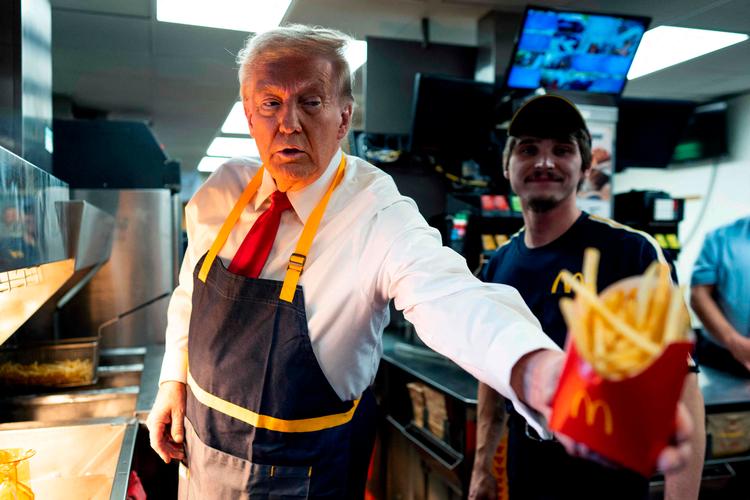 Donald Trump hjalp søndag kortvarigt med at lange pomfritter over disken i en McDonald's-restaurant i Pennsylvania. Foto: Pool/Ritzau Scanpix