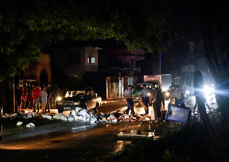 De omfattende strømafbrydelser i Cuba forrige uge udløste store gadeprotester. Her er politiet i hovedstaden, Havana, 19. oktober ved at fjerne skrald, som demonstranter havde brugt til at bygge en improviseret barrikade.  Foto: Norlys Perez/Ritzau Scanpix