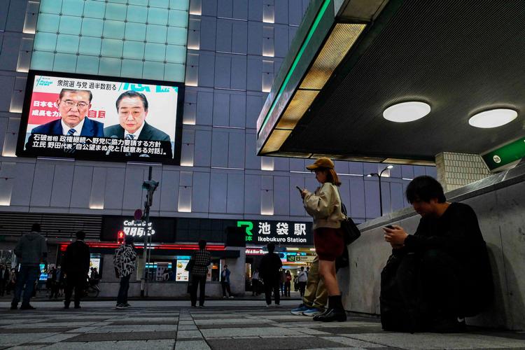 En nyhedsudsendelse viser billeder af Japans ministerpræsident, Shigeru Ishiba (tv.), og hans rival, Yoshihiko Noda fra oppositionspartiets CDPJ, på togstationen Ikebukuro i Tokyo. Deres to partier blev de største ved valget, men ingen af dem kan klare sig uden en koalition. Foto: Richard A. Brooks/Ritzau Scanpix