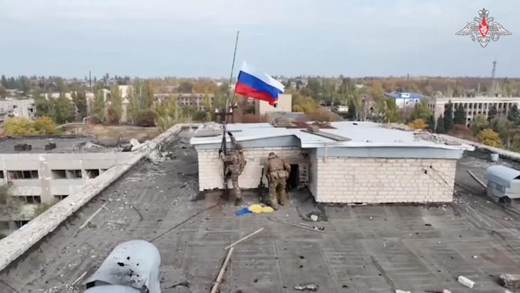 Russiske besættelsesstyrker hejser det russiske flag fra en bygning i Selydove, der netop er faldet. Foto: Russian Defence Ministry/Ritzau Scanpix