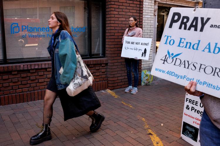 Christine (i midten af billedet) kommer typisk to gange om ugen for af bede bønner og protestere mod abort foran abortklinikken Planed Parrethood. Hun tænker, at de kvinder, der kommer ud fra klinikken, måske har brug for nogen at tale med, og derfor stiller hun sig gerne til rådighed.   Foto: Jacob Ehrbahn