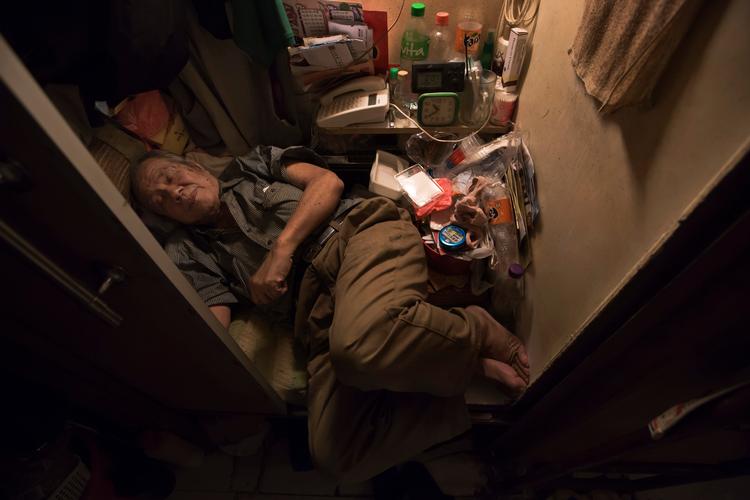 80-årige Cheung Chi-fong sover i sin mikroskopiske ’hulebolig’, hvor han ikke engang kan strække benene ud. Foto fra marts 2017. Foto: Kin Cheung/Ritzau Scanpix