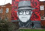 På en mur i Watford i Storbritannien er Elton John portrætteret på en baggrund af røde roser og med lukkede øjne. Foto: Matthew Childs/reuters/ritzau Scanpix/Ritzau Scanpix