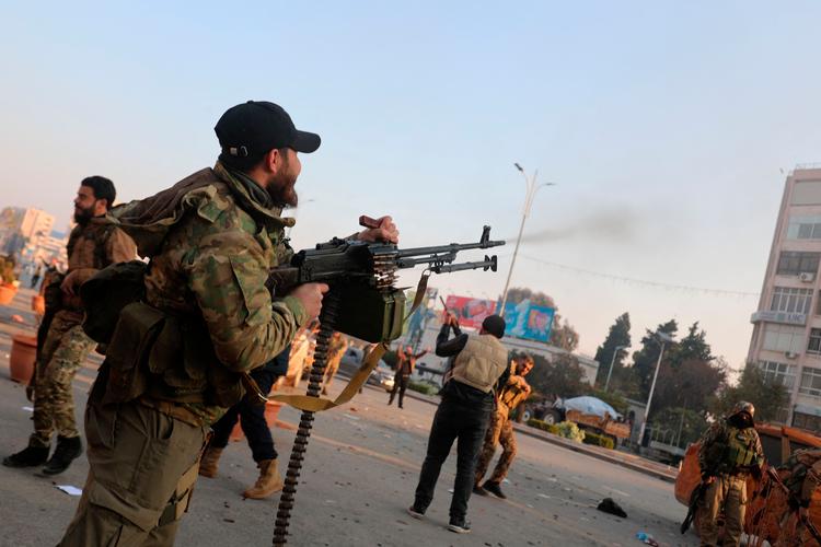 En militssoldat affyrer sit våben i glæde over, at byen Hama er blevet indtaget af oprørsstyrkerne i Syrien. Foto: Abdulaziz Ketaz/Ritzau Scanpix