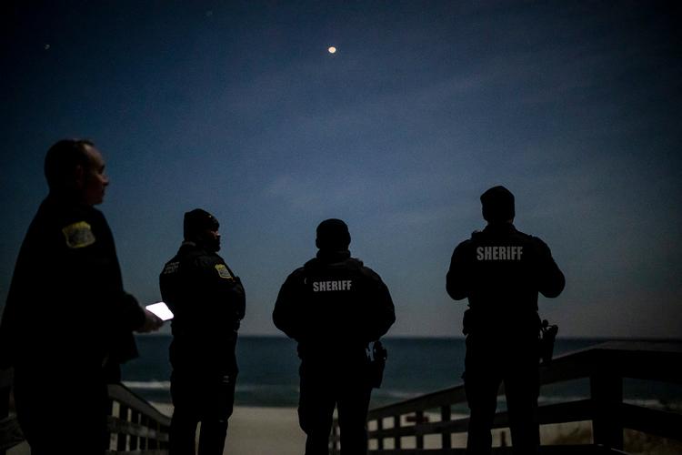 Politibetjente skuer op mod himlen for at holde øje med de mystiske droner, der flyver rundt over New Jersey. Foto: Dave Sanders/Ritzau Scanpix