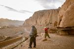 En bevæbnet talebaner holder vagt, mens en kinesisk turist tager billeder af resterne af en af Buddhastatuerne i Bamiyan – de to tårnhøje statuer blev sprængt i stykker af Taleban i 2001.  Foto: Elise Blanchard/Ritzau Scanpix