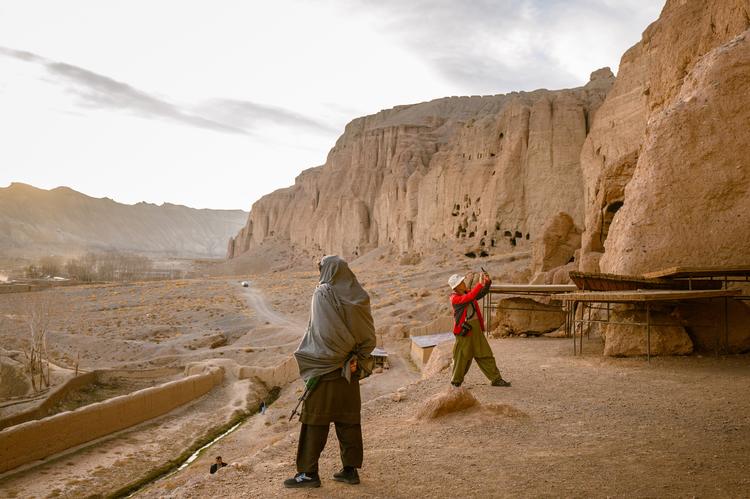 En bevæbnet talebaner holder vagt, mens en kinesisk turist tager billeder af resterne af en af Buddhastatuerne i Bamiyan – de to tårnhøje statuer blev sprængt i stykker af Taleban i 2001.  Foto: Elise Blanchard/Ritzau Scanpix