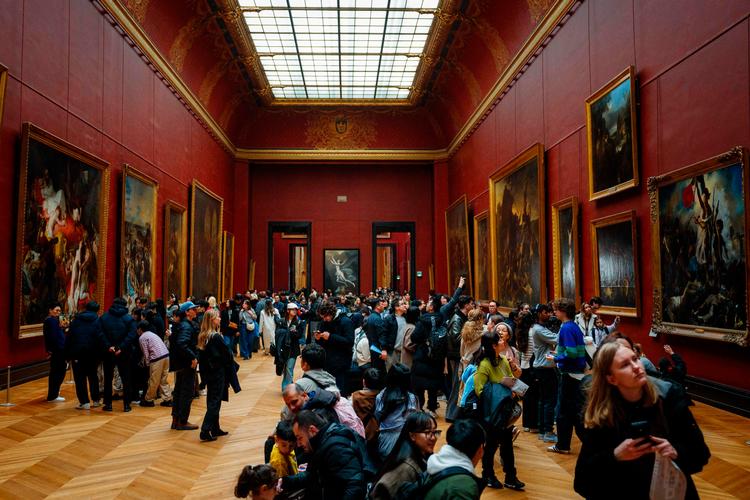 Et velbesøgt sted på Louvre er de røde rum, hvor nogle af de mest kendte franske malerier fra 1800-tallet hænger. Til højre er Eugène Delacroix’ maleri ’Friheden fører folket på barrikaderne’ (1830), der er blevet et symbol på den franske revolution. Foto: Dimitar Dilkoff/Ritzau Scanpix