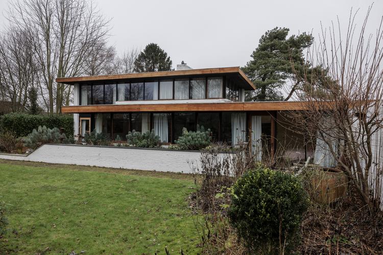 Huset er på 240 kvm og ligger på en 2.000 kvadratmeter stor grund. Fra havesiden mod syd åbner huset sig op med store vinduespartier og en terrasse indrammet af en mindre mur, mens en højere mur mod øst giver læ og privatliv. Hoveddøren i egetræ ligger i krydset, hvor bygningens to rektangler mødes. For enden af den ene rektangel fortsætter tagdelen og giver dermed en overdækket carport, der som resten af huset har sternbrædder i teaktræ. 