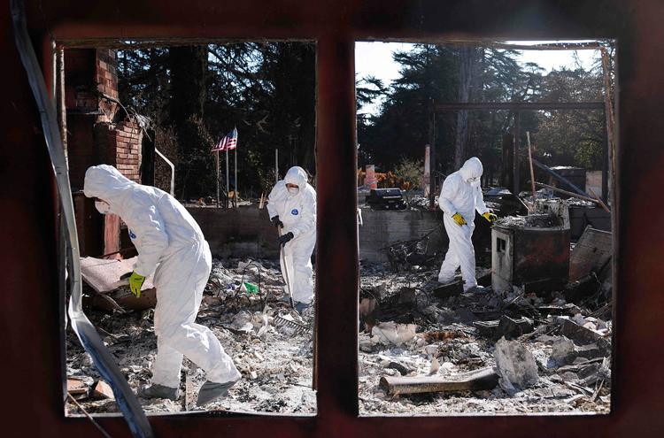 Nick Sonnenberg (tv.)  og hans forældre fotograferet tidligere på ugen, hvor de ledte efter ting ved deres nedbrændte hjem i Altadena i Calilfornien. Foto: Mario Tama/Ritzau Scanpix