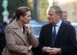 Statsminister Mette Frederiksen fordybet i samtale med den polske ministerpræsident Donald Tusk på vej ind til topmøde i Palais d’Egmont i Bruxelles. Foto: Olivier Hoslet/Ritzau Scanpix