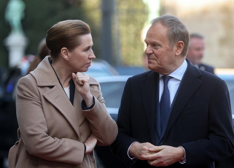 Statsminister Mette Frederiksen fordybet i samtale med den polske ministerpræsident Donald Tusk på vej ind til topmøde i Palais d’Egmont i Bruxelles. Foto: Olivier Hoslet/Ritzau Scanpix