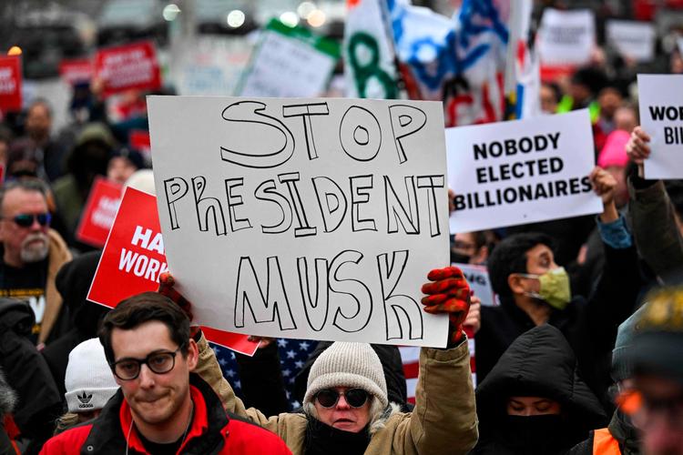 Demonstranter protesterer mod Elon Musks effektivitetskrig i en række statslige organer i USA. Historikeren Douglas Brinkley beskriver Musk som en ’ensom hævner’ med ubegrænset manøvrefrihed
 Foto: Drew Angerer/Ritzau Scanpix