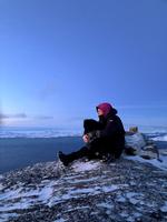 Hansine Steenholdt sætter sig højt oppe på fjeldet ved Nuuk og nyder udsigten i et stille øjeblik sammen med sin hund Lili. Foto: Kirsten Nilsson