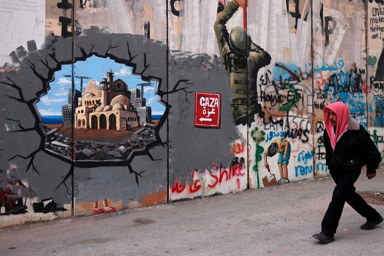 Udsigt til ’Mellemøstens riviera’. Palæstinensisk graffiti på Israels mur mellem Vestbredden og Israel. Det er Trumps idé at omdanne Gaza til et ferieparadis. Først vil han have palæstinenserne ud af landstriben.
 Foto: Hazem Bader/Ritzau Scanpix