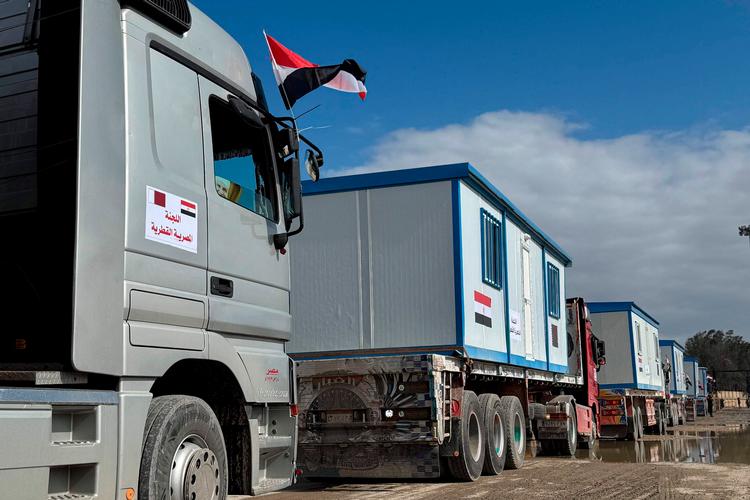 Lastbiler med container-boliger står i kø på den egyptiske side af grænsen til Gaza. Den israelske regeringer afviser at lade dem køre ind i Gaza. Foto: Str/Ritzau Scanpix