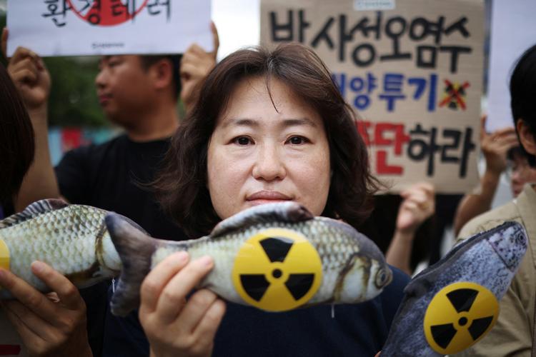 Fukushima er kendt for sine afgrøder og fisk, men mange tør stadig ikke spise dem af frygt for radioaktiv stråling. 
Her poserer en aktivist i Sydkorea imod, at Japan vil hælde spildevand fra Fukushima-atomkraftværket ud i havet. Foto: Kim Hong-ji/Ritzau Scanpix