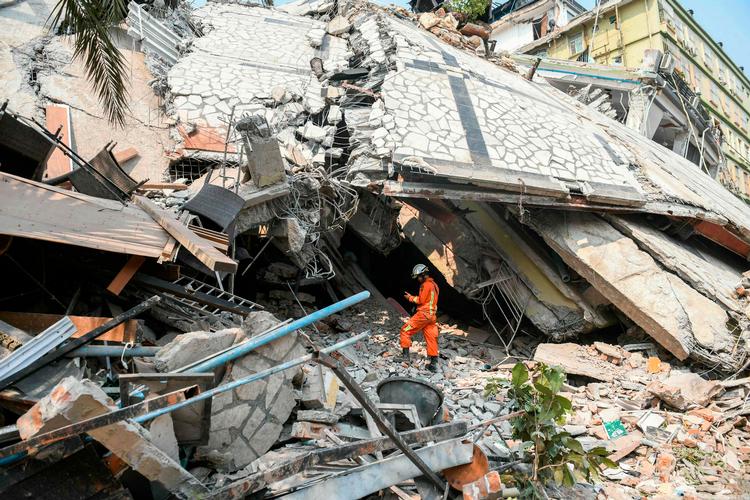 Et redningshold forsøger at befri fastklemte beboere i Myanmars næststørste by, Mandalay, efter et voldsomt jordskælv har ramt landet. Mere end 90 mennesker kan være fanget inde i de knuste rester af lejlighedsblokken, som ses på billedet, fortæller en Røde Kors-ansat til AFP.  Foto: Sai Aung Main/Ritzau Scanpix