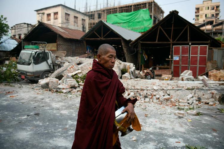 En munk passerer et ødelagt hus i byen Mandalay i Myanmar søndag, to dage efter at et jordskælv ramte landet. 
 Foto: Sai Aung Main/Ritzau Scanpix