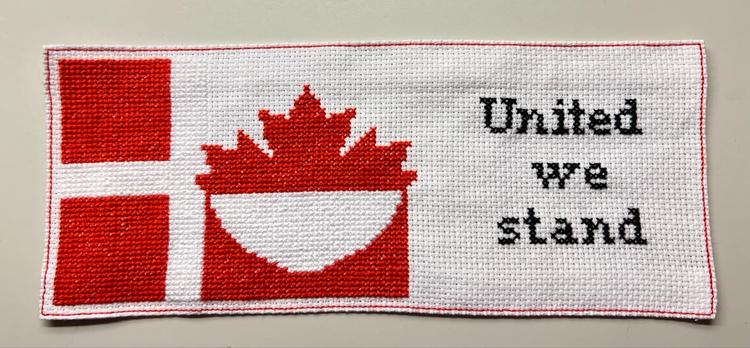 Helen Dworak har sørget for noget af udsmykningen i facebookgruppen 'Boykot varer fra USA'. Hendes rød-hvide broderi rummer både Danmarks, Canadas og Grønlnads flag. 