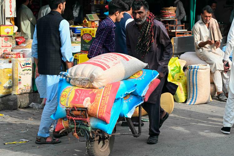 En arbejder transporterer fødevarer på et marked i den pakistansk kontrollerede del af Kashmir. De pakistanske myndigheder har bedt befolkningen samle et lager af mad som forberedelse til et forventet angreb fra Indien.  Foto: Farooq Naeem/Ritzau Scanpix